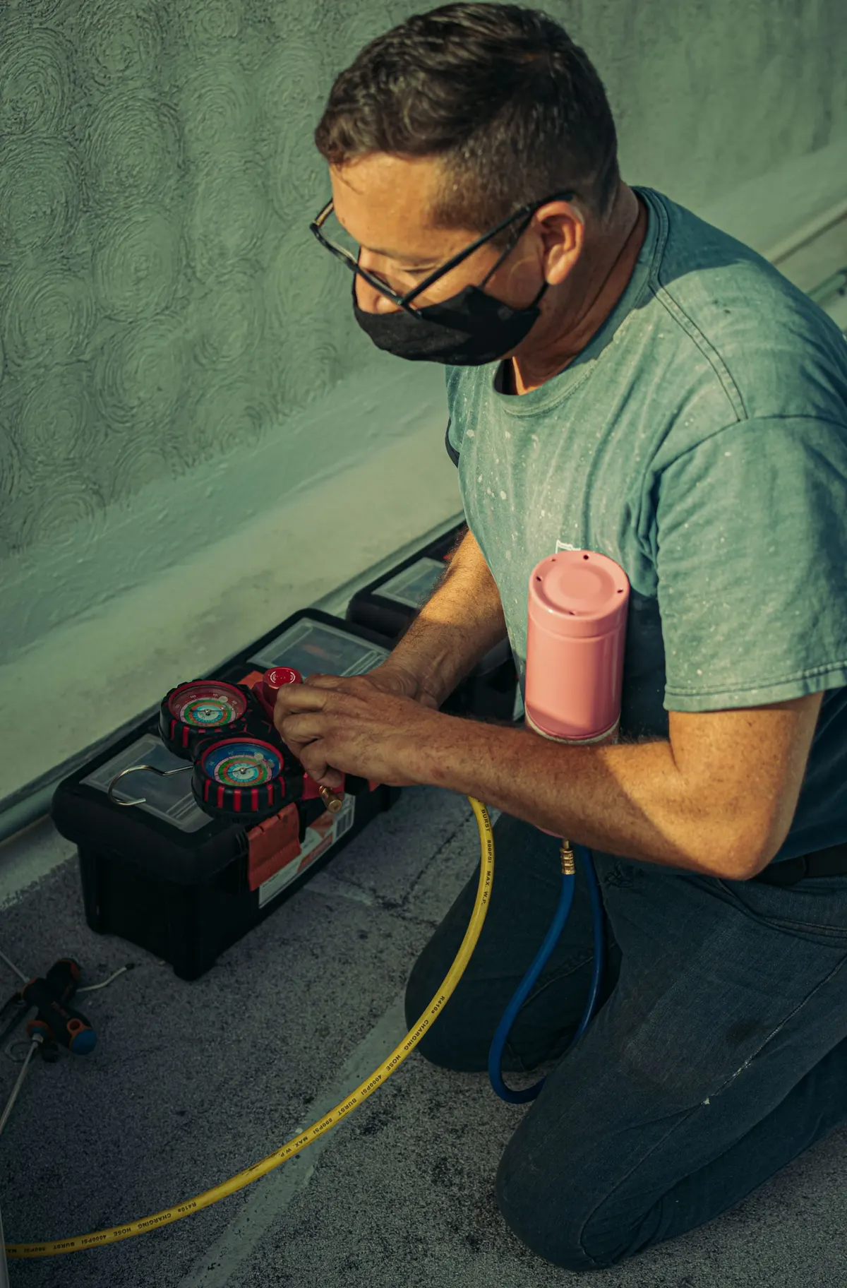 Monteur werkt met een koudemiddelcilinder bij een warmtepomp-installatie.